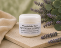 A white jar of Meadowlake Farm Prevention Complex Blemish Control Face Cream sits on a textured beige stone slab, surrounded by lavender sprigs and a soft beige cloth against a blurred green background.